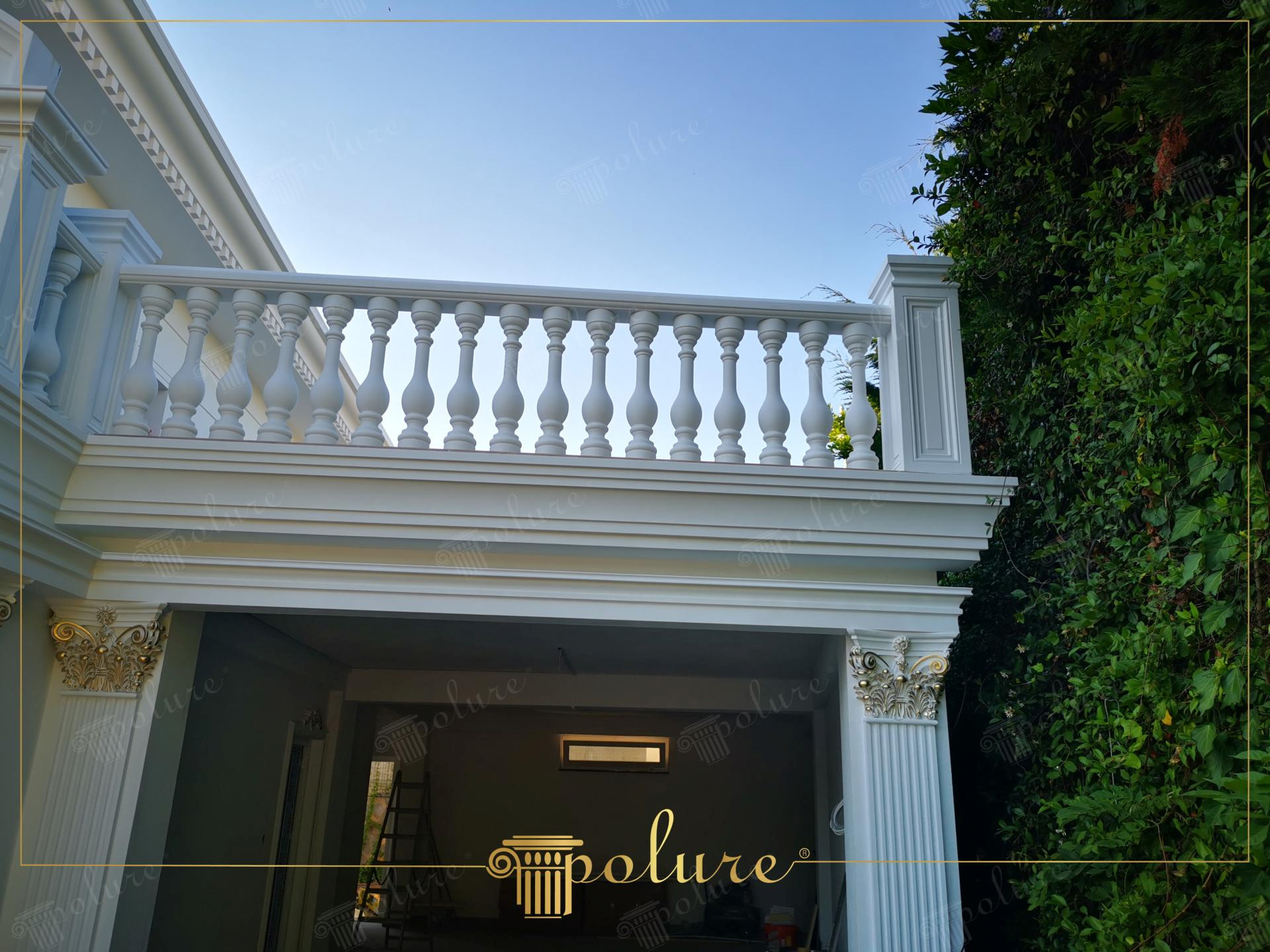 Altın rengi motifli pilaster sütun başlıkları, geniş kat silmesi ve beyaz poliüretan balustrad balkon korkuluklarının yer aldığı villa girişi.
