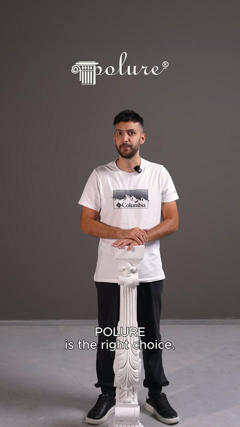 Sunucu stüdyoda kabartma motifli dekoratif sütun parçasını dikey olarak sergiliyor