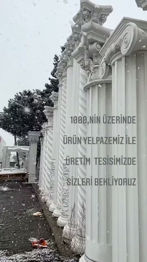 Üretim sahasında sıralanan beyaz dekoratif sütunlar ve işlemeli başlıklar görülüyor.