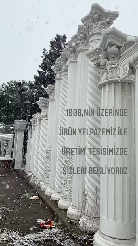 Yan yana duran sütun örnekleri, kabartmalı gövde ve başlıklar sunuyor.