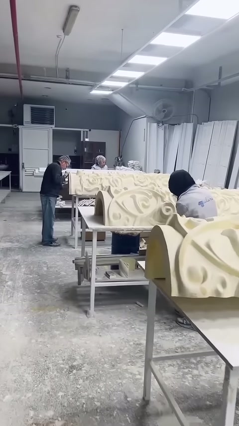 İki usta kabartmalı kaide parçalarının yüzey düzenlemelerini sürdürüyor