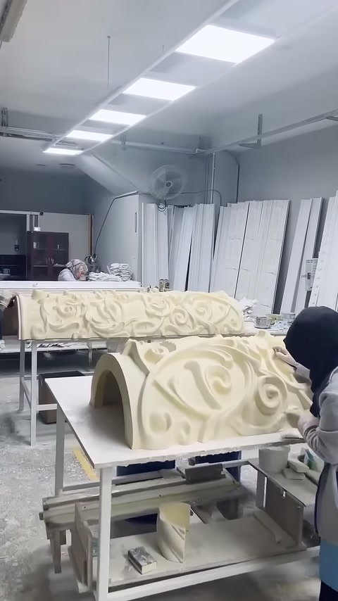 Yakındaki kaide parçasının kabartmalı yüzeyi usta tarafından işleniyor
