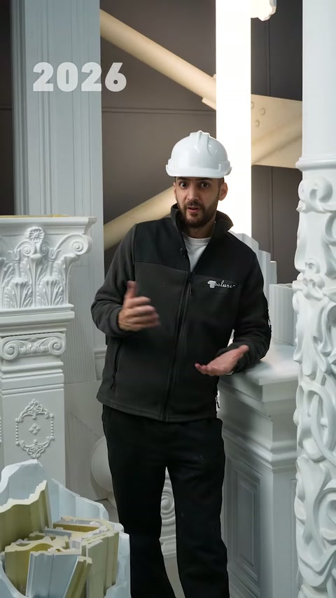 Beyaz baretli tanıtımcı dekoratif sütunların arasında ürünleri anlatıyor