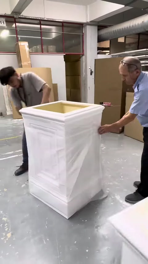 Tamamlanan pilaster sütun başlığı iki çalışan tarafından konumlandırılıyor
