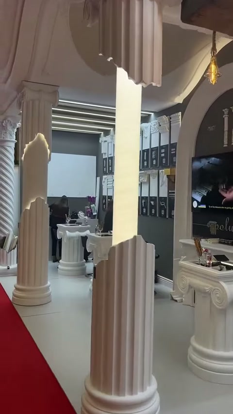 Fuar alanındaki yüksek sütunlar ve başlık biçimli sergileme masası öne çıkıyor
