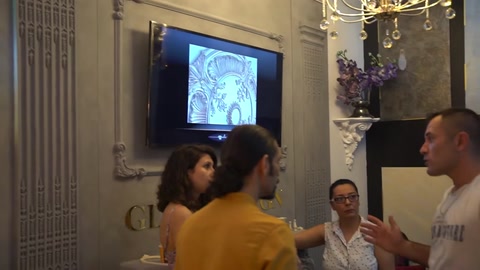 Duvarda ekran ve sütunlarla dekore edilmiş sergi salonu genel görünümü