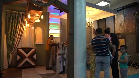 Ziyaretçiler sütunlu ve panelli mağaza girişinde dekorasyonu inceliyor