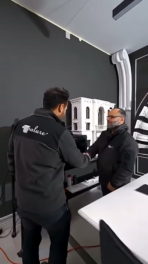 Beyaz dekoratif parçalarla çevrili stantta ürün incelemesi yapılıyor.
