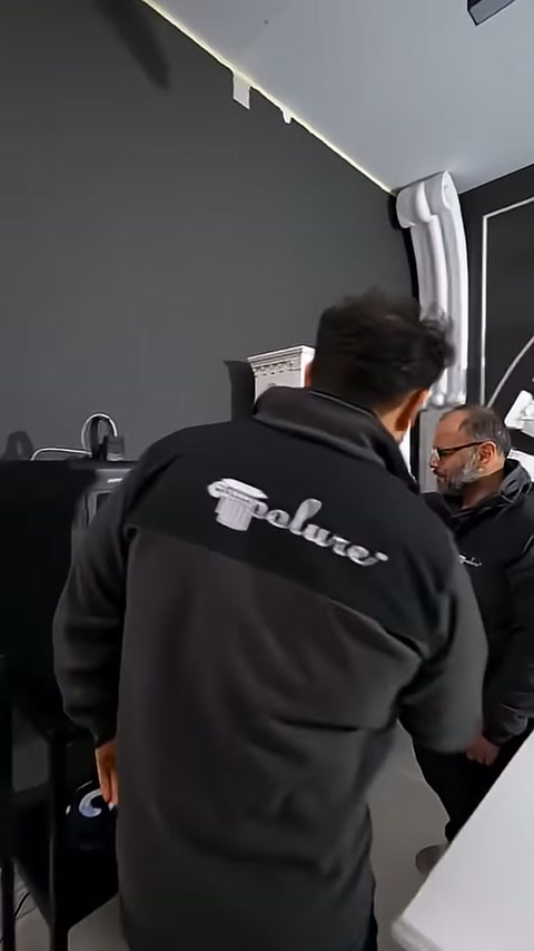 Siyah sergileme duvarı önünde beyaz minyatür cephe maketi bulunuyor.
