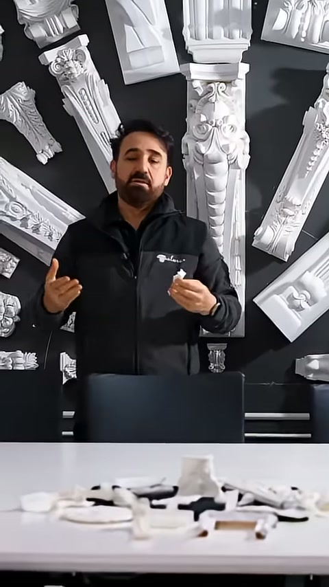 Görevli dekoratif sütun örnekleri önünde minyatür ürünü anlatıyor.