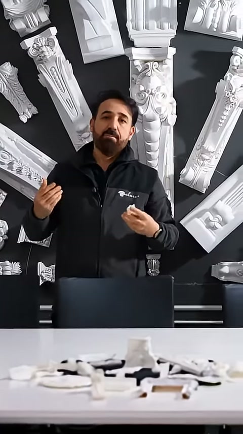 Stand görevlisi elindeki beyaz parçayı kameraya dönerek tanıtıyor.
