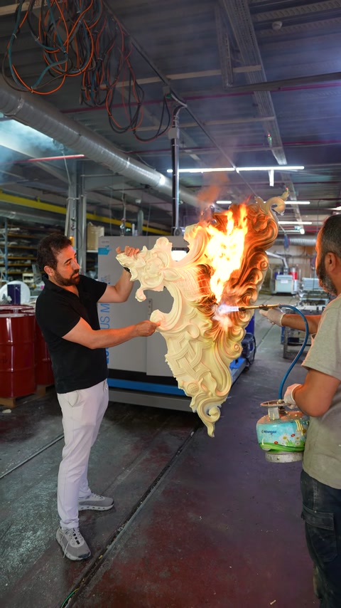 Atölyede oyma desenli dekoratif parçaya alev testi uygulanıyor.