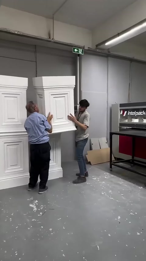 İki çalışan, farklı boyutlardaki pilaster kaidelerini birlikte inceliyor.