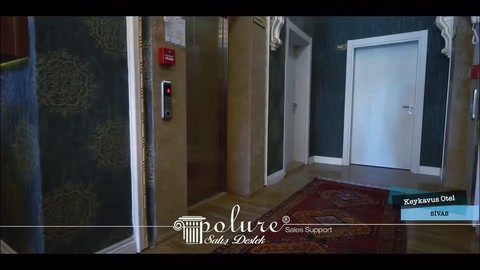 Koyu kaplamalı duvarlar arasında sade otel asansör holü