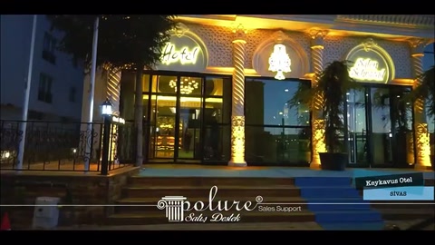 Video, gece ışıklarıyla vurgulanan gösterişli otel giriş cephesini gösteriyor