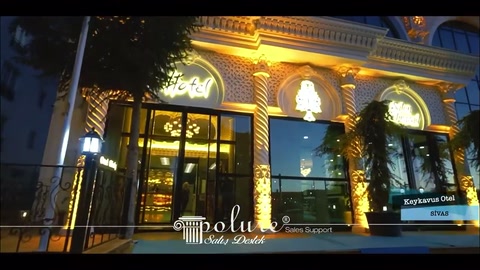 Otel girişindeki yüksek cam kapılar dekoratif cephe elemanlarıyla çevreleniyor