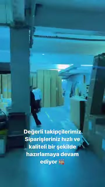 Çalışan, poliüretan parçaların bulunduğu üretim koridorunda ilerliyor.