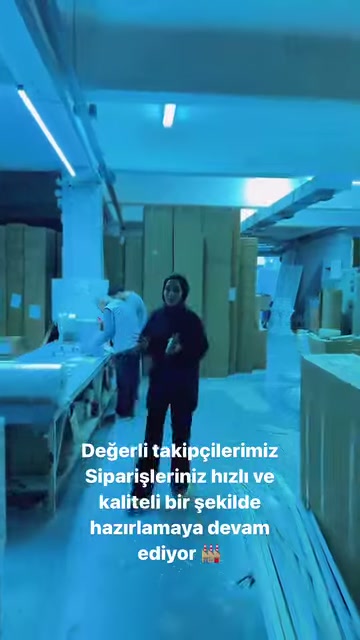 Çalışan, kalıplarla çevrili atölye geçidinde ürünleri tanıtıyor.
