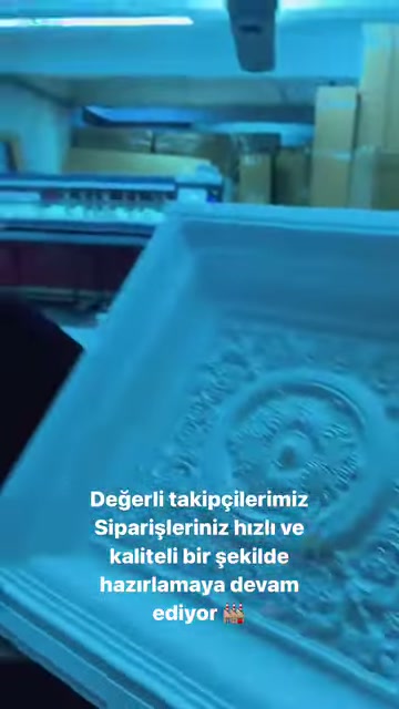 Çiçek motifli kabartma panel, üretim makinesinin önünde gösteriliyor.