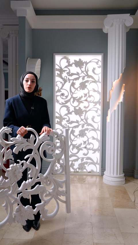 Dekupe dekoratif panel, uygulama örneğinin önünde elde sergileniyor