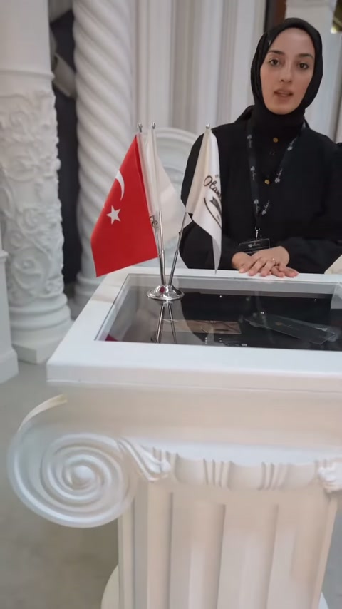 Sunucu bayrakların arkasında volütlü dekoratif başlığın kullanımını anlatıyor