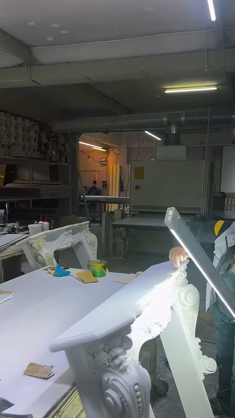 İşçi, oymalı sütun başlığını aydınlatılmış çalışma tezgâhında hazırlıyor.