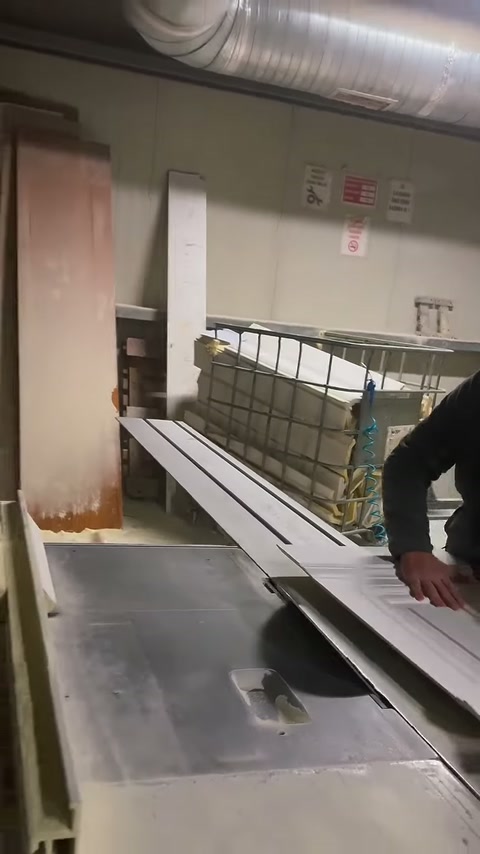 Çalışanın eli, tezgâhtaki sıralı profillerin uçlarını yönlendiriyor.
