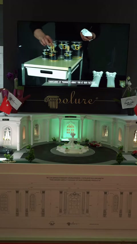 Dekoratif maket ve küçük araç modeli, stand vitrini üzerinde sergileniyor
