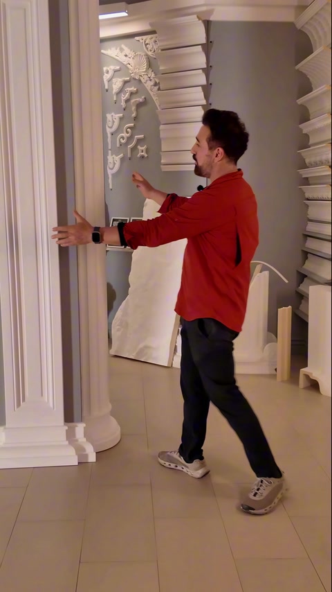 Sunucu showroom panosundaki yivli pilastr gövdeyi çevirerek tanıtıyor
