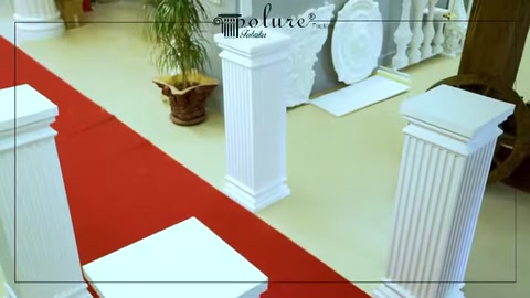 Kırmızı halı boyunca sıralanan kısa beyaz sütun modelleri