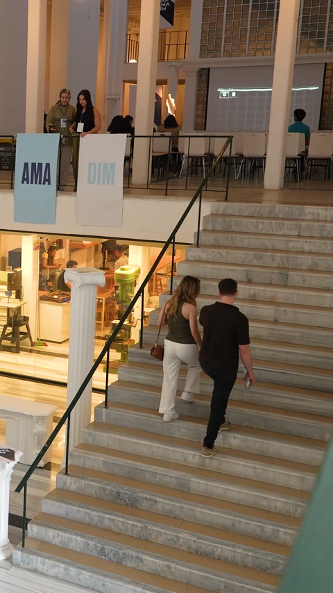 Merdivenli etkinlik mekânında sunum alanı ve dekoratif sütunlar görülüyor