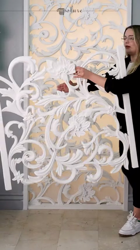 Sunucu, dekupe panel üzerindeki kabartmalı çiçek motifine işaret ediyor