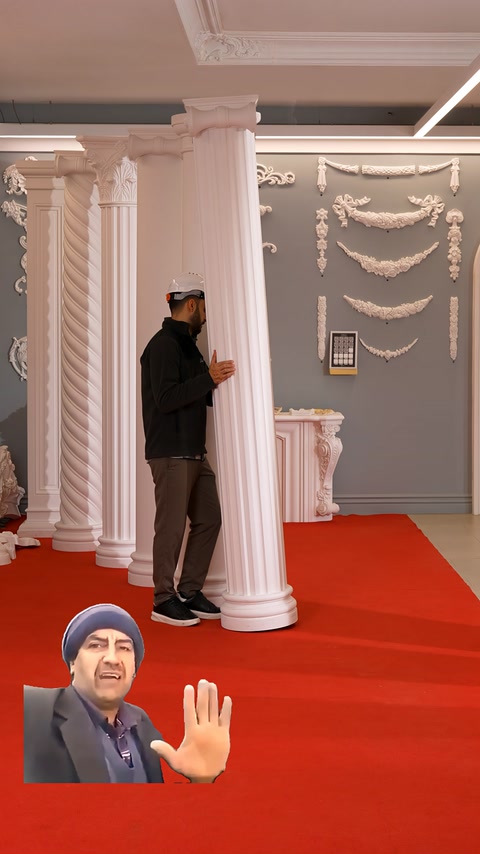 Yuvarlak yivli sütun, dekoratif duvar süslemeleri önünde inceleniyor.