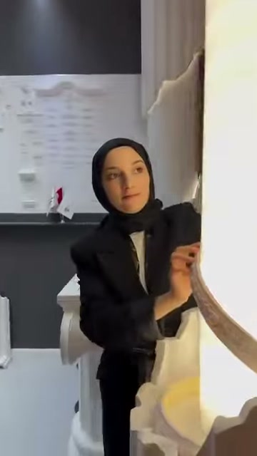 Kahverengi flex profil, beyaz sütun önünde yay halinde tutuluyor