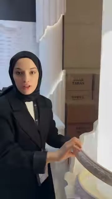 Kahverengi süsleme profili, beyaz sütun çevresinde kavisli tutuluyor