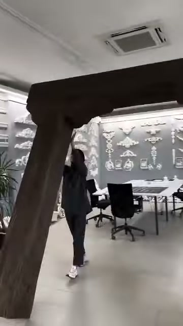 Tanıtım görevlisi kütük çerçevenin altında ürün yapısını inceliyor