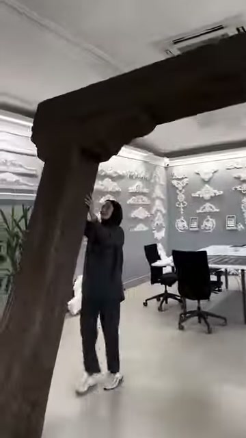 Görevli dekoratif kütüğün üst bölümünü eliyle işaret ederek anlatıyor