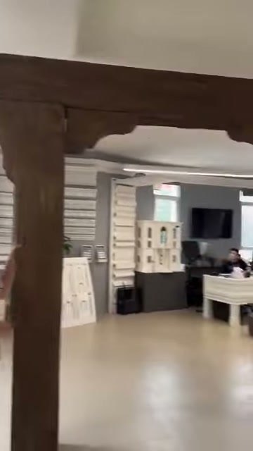 Kamera dekoratif kütük çerçeveden showroomun açık sergi alanına yöneliyor