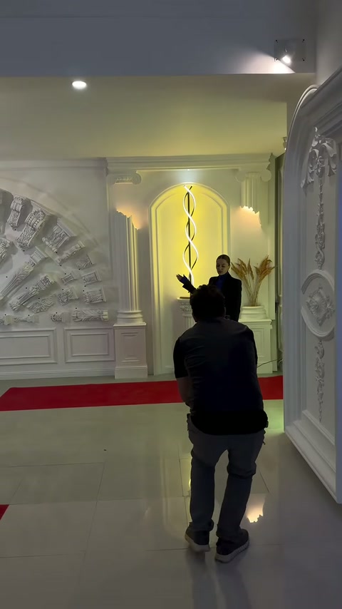 Aydınlatmalı sütunlu niş önünde ürün tanıtım videosu kaydediliyor