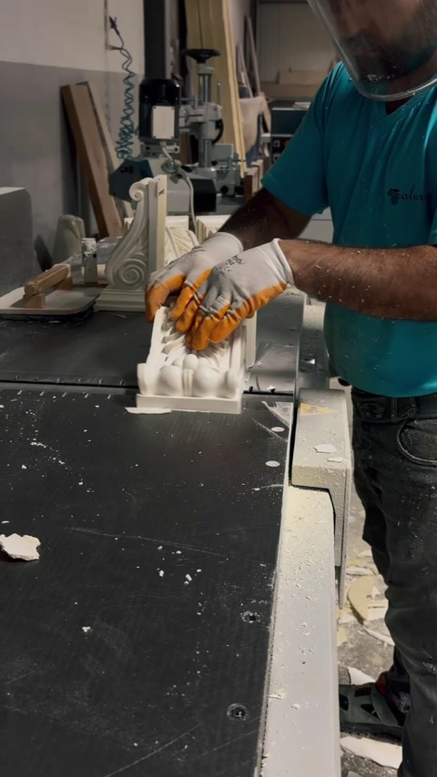 Dekoratif sütun başlığı eldivenli çalışan tarafından makinede kesiliyor