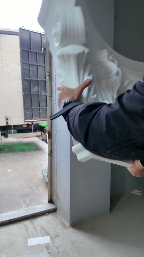 Korint başlığındaki katmanlı akant yapraklarına elle dokunuluyor.