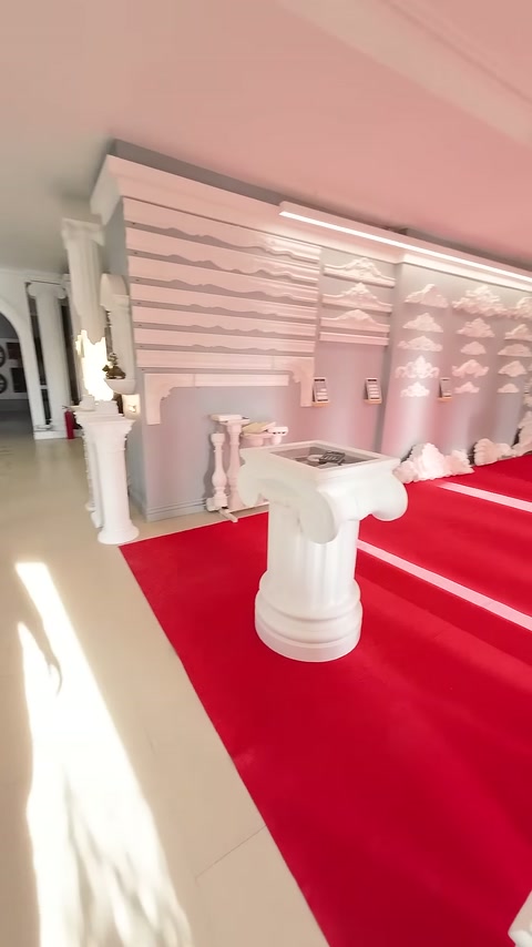 Kırmızı halılı bölümde sütun başlıkları ve kaideler düzenli sergileniyor.