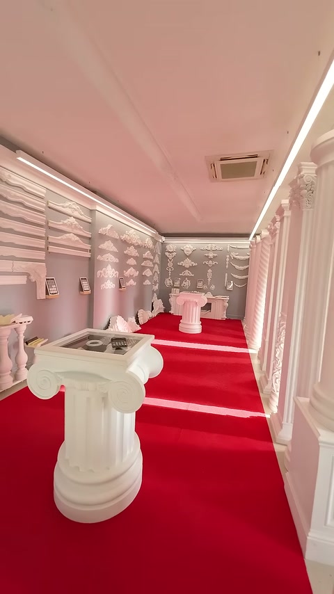 Showroomun kırmızı halılı alanında başlık, kaide ve bordür örnekleri bulunuyor.