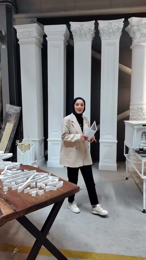 Sunucu, masadaki tabela elemanlarından bir parçayı elinde tutuyor.