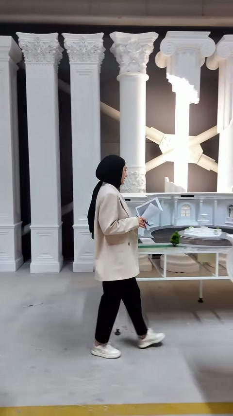 Sunucu, elindeki beyaz tabela parçasıyla çalışma alanında ilerliyor.