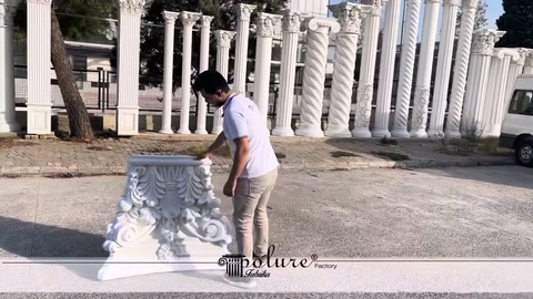 Beyaz poliüretan sütun başlığı açık alanda zeminde inceleniyor