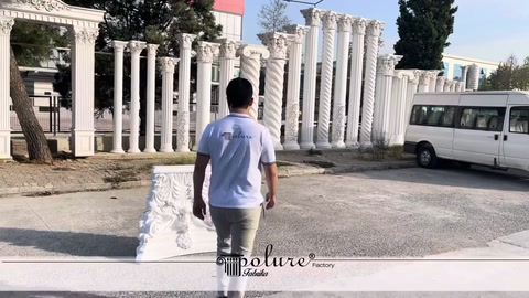 Açık alanda beyaz korint sütun başlığı yerde sergileniyor