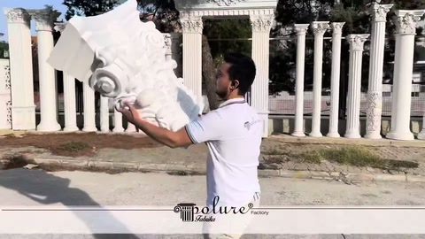 Görevli büyük beyaz sütun başlığını göğüs hizasında tutuyor