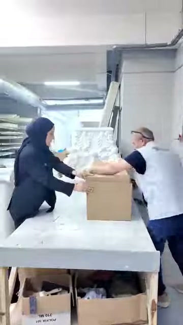 Kabartmalı beyaz dekoratif parça açık kutunun içine yerleştiriliyor.