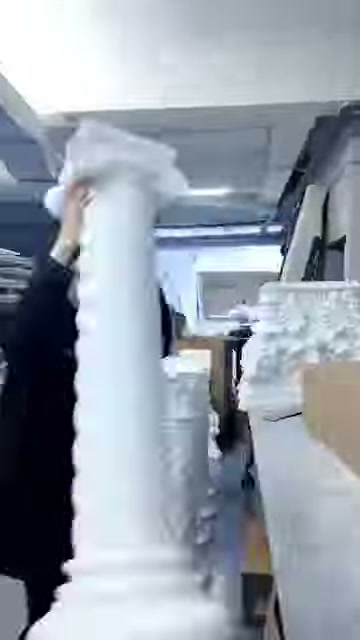 Sunucu, uzun yivli beyaz sütun parçasını dik biçimde taşıyor.